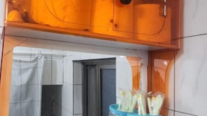 Une salle de bain équipée d’un miroir, d’un distributeur de serviettes et d’un rouleau de papier toilette.