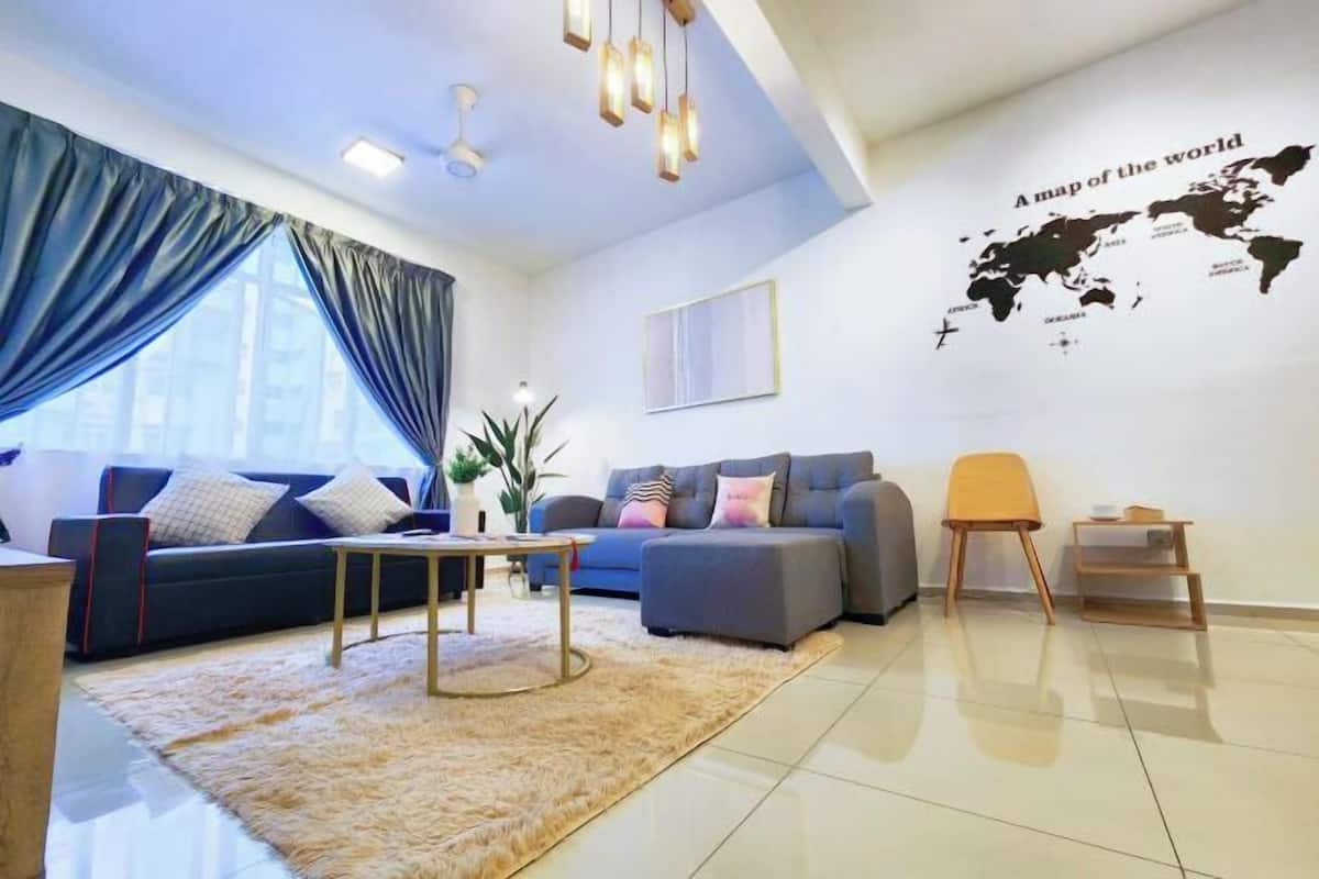 A modern living room with a sofa, ottoman, coffee table, and a world map on the wall.
