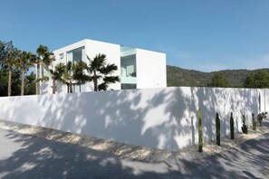 Un bâtiment moderne avec une façade blanche, de grandes fenêtres et un toit plat.