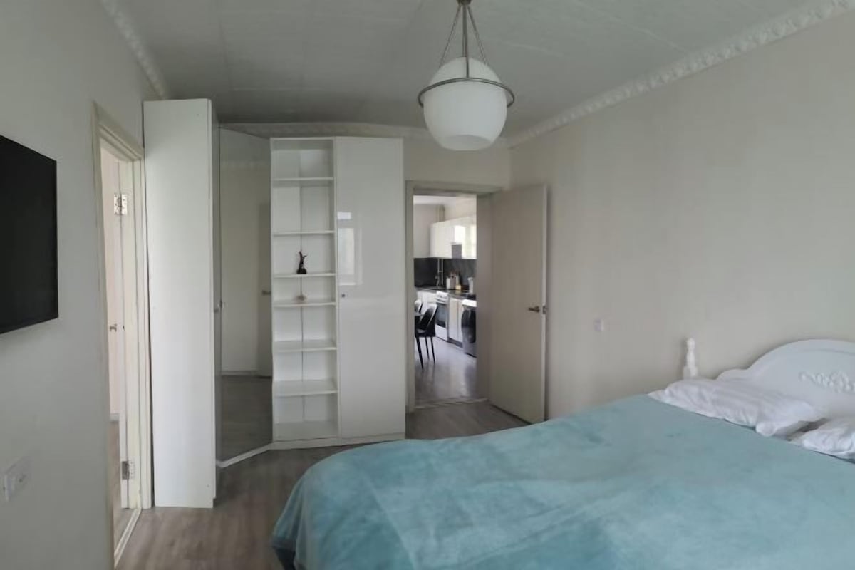 Una camera da letto con un letto, un armadio e un corridoio che conduce a una cucina.