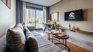 A modern living room with a sofa, a coffee table, and a TV mounted on the wall. - Casablanca Maarif City Center (Casablanca)