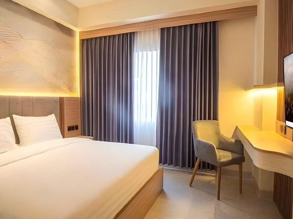 Une chambre d’hôtel avec un grand lit, un bureau et une chaise.