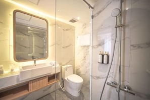 A modern bathroom with a marble sink, toilet, and shower. - Grand Altuz Yogyakarta (Depok)