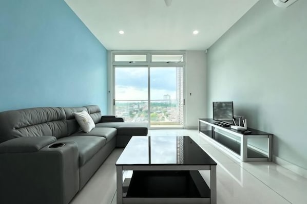 A modern living room with a grey sofa, a coffee table, and a TV on a stand. - KSL D'Esplanade 2Bedrooms 7-8pax Shopping Heaven (Johor Bahru)