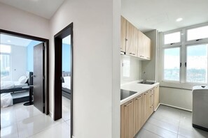 A modern kitchen with wooden cabinets, a countertop, and a window providing a city view. - KSL D'Esplanade 2Bedrooms 7-8pax Shopping Heaven (Johor Bahru)