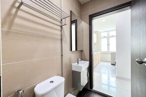 Ein modernes Badezimmer mit Toilette, Waschbecken und Handtuchhalter.