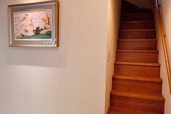 A wooden staircase with a framed picture on the wall. - HAKUKOU UROMURO (Kyoto)