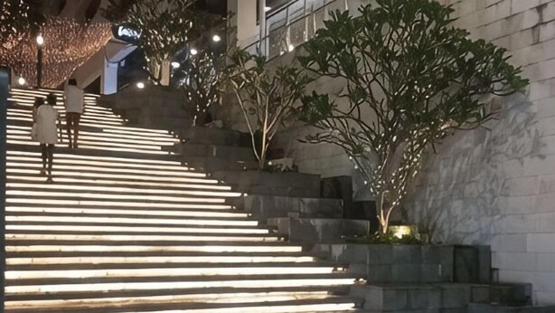 A staircase with illuminated steps, a tree, and a building in the background. - Seaview-Pinetree Marina Resort 2BR [Puteri Harbour] - 5 mins to Legoland (Iskandar Puteri)