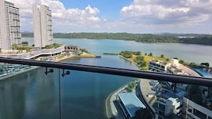 A high-rise hotel with a view of a lake and surrounding greenery. - Seaview-Pinetree Marina Resort 2BR [Puteri Harbour] - 5 mins to Legoland (Iskandar Puteri)