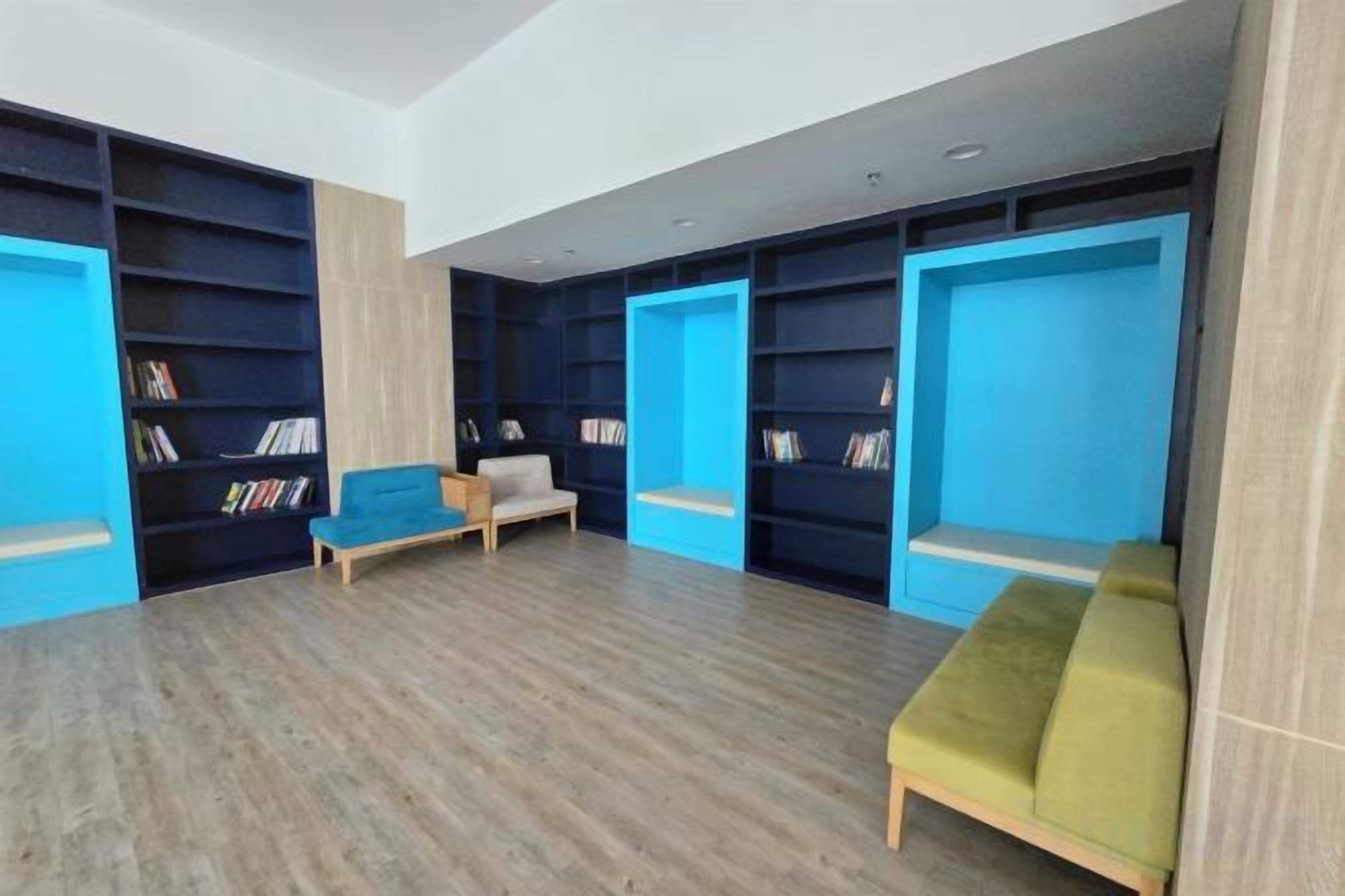 A room with bookshelves, a sofa, and a bench.