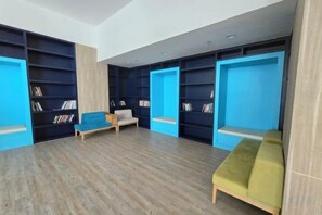 A room with bookshelves, a sofa, and a bench. - Seaview-Pinetree Marina Resort 2BR [Puteri Harbour] - 5 mins to Legoland (Iskandar Puteri)