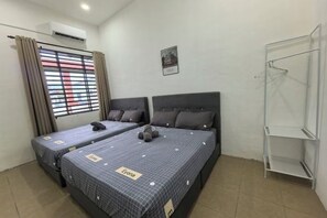 A hotel room with two beds, a window with blinds, a wall-mounted air conditioner, a small framed picture, and a white metal shelf. - Homestay Sungai Karangan Near Inokom (Padang Meha)