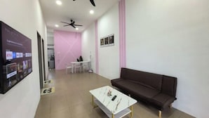A modern living room with a sofa, a coffee table, and ceiling fans. - Homestay Sungai Karangan Near Inokom (Padang Meha)