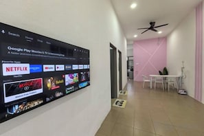 A hallway with a large digital screen displaying a Google Play Movies & TV interface. - Homestay Sungai Karangan Near Inokom (Padang Meha)