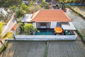 A two-story house with a swimming pool, surrounded by a white fence and palm trees. - Dijero at Umah Bali (Bali)