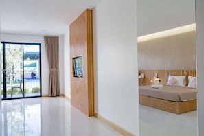 A modern hotel room with a large bed, a wooden accent wall, and a sliding glass door leading to an outdoor area. - Bed Resort Sadao (Sadao)