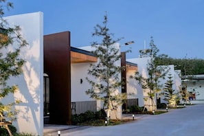 A modern residential building with a clean design, featuring a prominent entrance and a well-maintained garden area. - Bed Resort Sadao (Sadao)