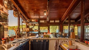 A rustic kitchen with wooden beams, a sink, and various cooking utensils. - ZadarVillas Off-Grid Private Island Retreat (Sali)