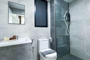 A modern bathroom with a glass shower enclosure, a white sink, and a toilet. - Putrajaya Antara Residence Air-Con Suite Facing Lake View (Putrajaya)