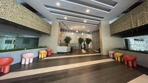 A modern hotel lobby with a reception desk, seating areas, and a patterned wall design. - Putrajaya Antara Residence Air-Con Suite Facing Lake View (Putrajaya)