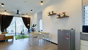 A modern living room with a dining area, a kitchen, and a large window with curtains. - Putrajaya Antara Residence Air-Con Suite Facing Lake View (Putrajaya)