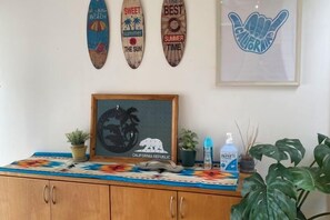A room with a wooden cabinet, a framed picture, and three wooden signs on the wall. - HOTEL YANBARUNIA (Nago)