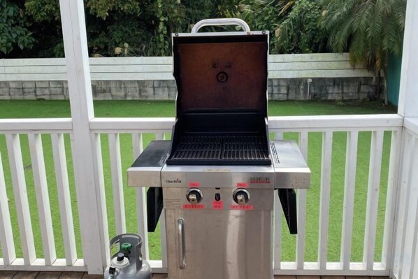 A portable grill with a digital display and control knobs, placed on a deck with a white railing. - HOTEL YANBARUNIA (Nago)
