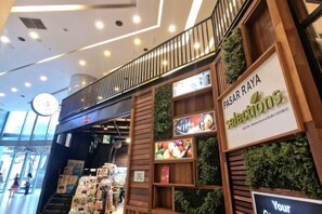 Un magasin avec une enseigne indiquant : « PASAR RAYA, sélection de produits ».