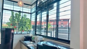 A kitchen with a large window, a refrigerator, and a countertop with a kettle and plates. - Fairy Retreat Private Pool@12-13pax (Ipoh)