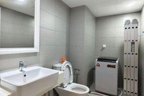 Une salle de bain équipée d’un lavabo, de toilettes et d’un espace douche.