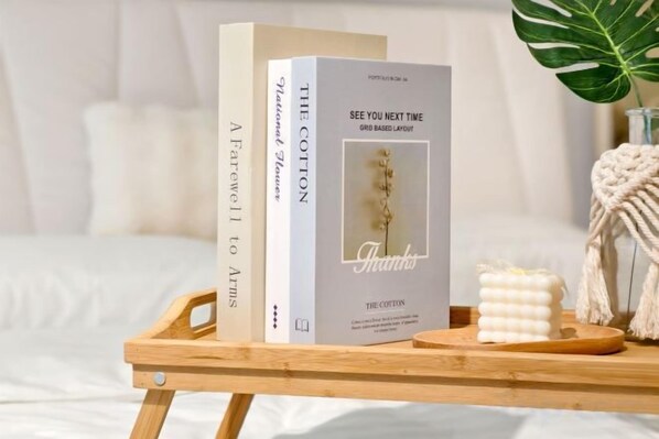 A wooden tray with books and a small plant on a bed with white bedding. - EkoCheras LumaStay (Kuala Lumpur)