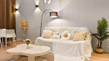 A cozy living room with a sofa, a coffee table, and a lamp.