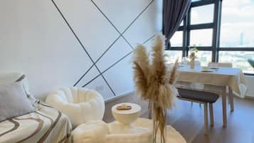 A modern room with a bed, a dining table, and a view of the city.