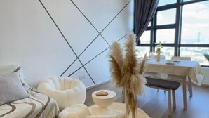 A modern room with a geometric wall design, a dining area with a table and bench, and a view of the city through large windows. - EkoCheras LumaStay (Kuala Lumpur)