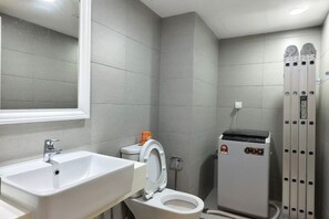 Un baño con lavamanos, inodoro y calentador de agua.