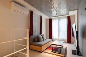 A modern living room with a sofa, a coffee table, and a TV. - Leclerc Higashi-Shinjuku (Shinjuku)