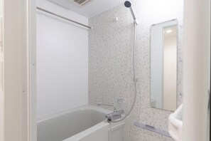 A bathroom with a bathtub, a shower, and a mirror. - Leclerc Higashi-Shinjuku (Shinjuku)