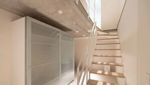 A modern interior with a staircase, a glass partition, and a light-colored floor. - Leclerc Higashi-Shinjuku (Tokyo)