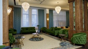 A modern hotel lobby with green sofas, a patterned rug, and two chandeliers. - Grand Plaza Hotel Samarkand (Samarkand)