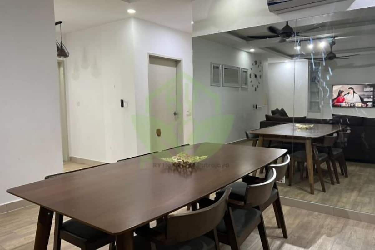 Un espace de restauration moderne avec une longue table en bois et de nombreuses chaises.