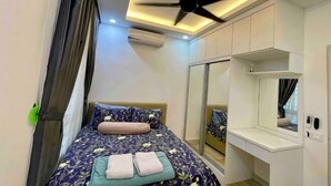 Een slaapkamer met een bed, een plafondventilator, een spiegel en een raam.
