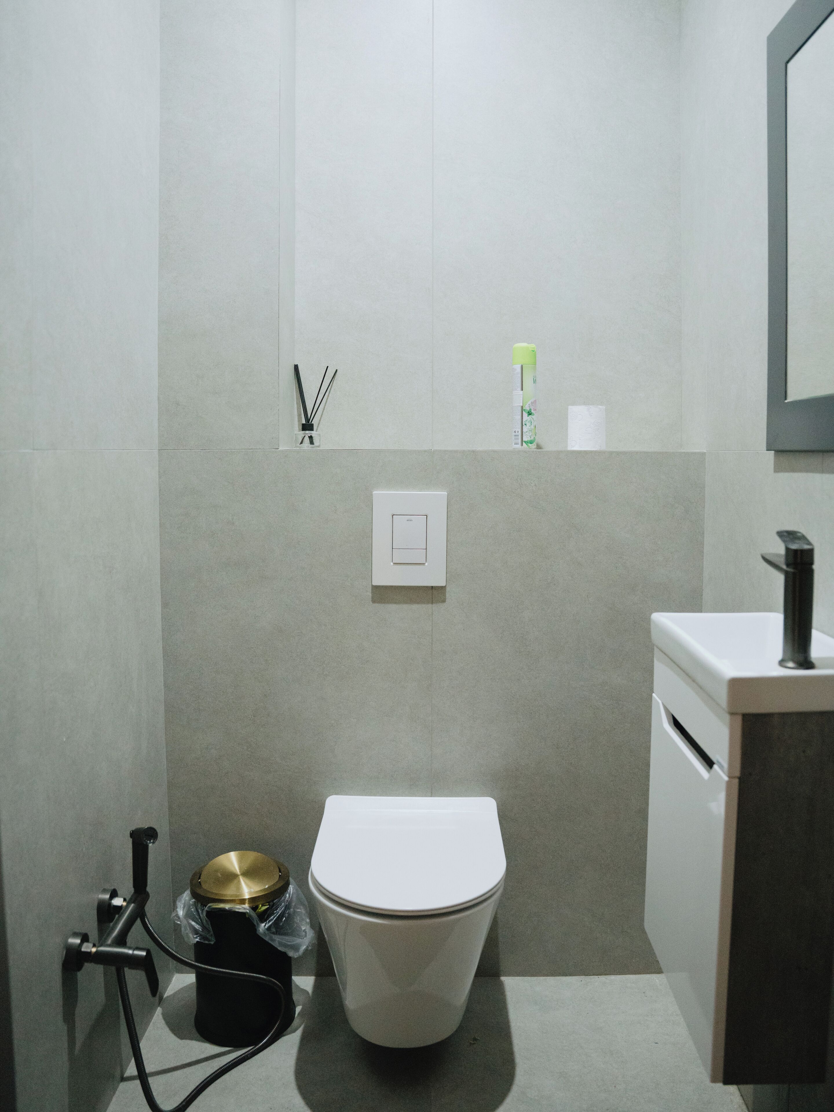 A modern bathroom with a toilet, a sink, and a shower.