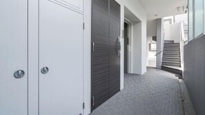 Ein Flur mit modernem Design, mit grauem Teppich und einer Kombination aus weißen und dunkelgrauen Türen.
