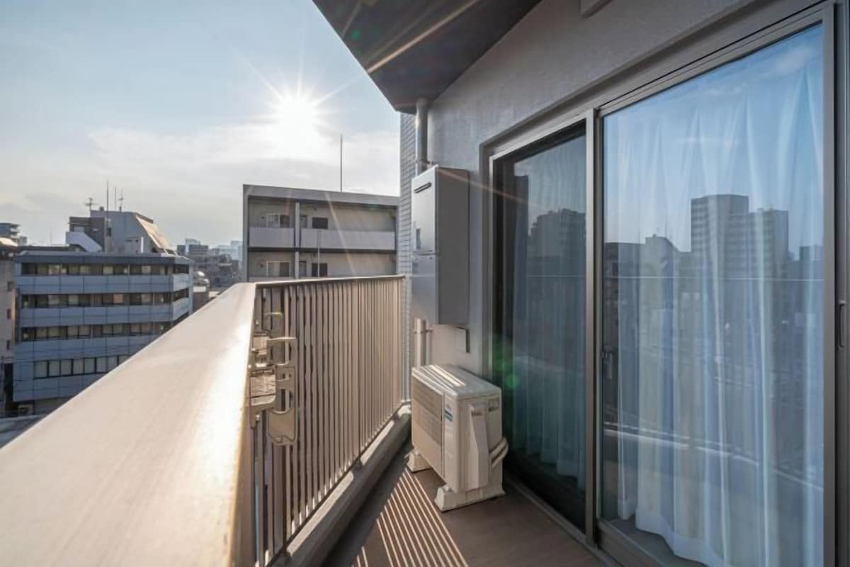 En balkong med utsikt över stadsbilden, en skjutdörr i glas och en inbyggd luftkonditioneringsanläggning.