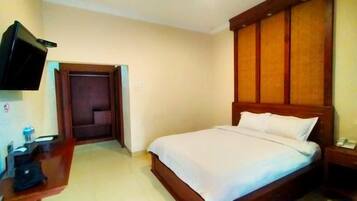 A hotel room with a bed, a television, a desk, and a wardrobe.