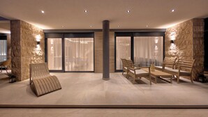 Un interior moderno con una zona de estar que incluye un sofá, sillas y una mesa de centro.