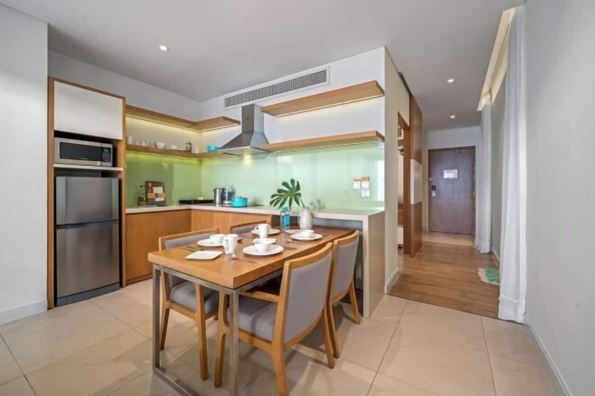 A modern kitchen with a dining area, stainless steel appliances, and a view of the outdoors.