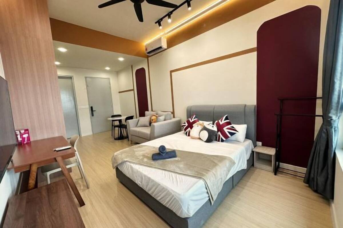 A modern hotel room with a bed, a desk, a chair, and a small table.