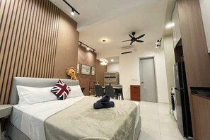 A modern hotel room with a bed, a desk, a chair, a wardrobe, and a ceiling fan. - The Pano at Jalan Ipoh Near KLCC By The Homez (Kuala Lumpur)