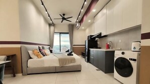 A modern hotel room with a bed, a washing machine, and a kitchenette. - The Pano at Jalan Ipoh Near KLCC By The Homez (Kuala Lumpur)